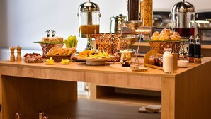 A buffet table with various food items and beverages, including pastries, cheeses, and a coffee station. - Paliani Hostel (Mestia)