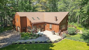 A large, two-story wooden house with a covered patio and a small deck. - Sebago Pine Lodge +Bonus Yurt! (Windham)