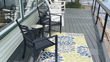 A deck with outdoor seating and a view of the lake.