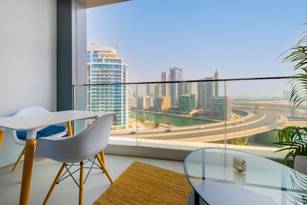 Enjoy a panoramic city view from this stylish room with a large window, glass table, and modern design.