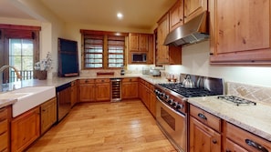 A kitchen with wooden cabinets, a stainless steel stove, and a microwave.