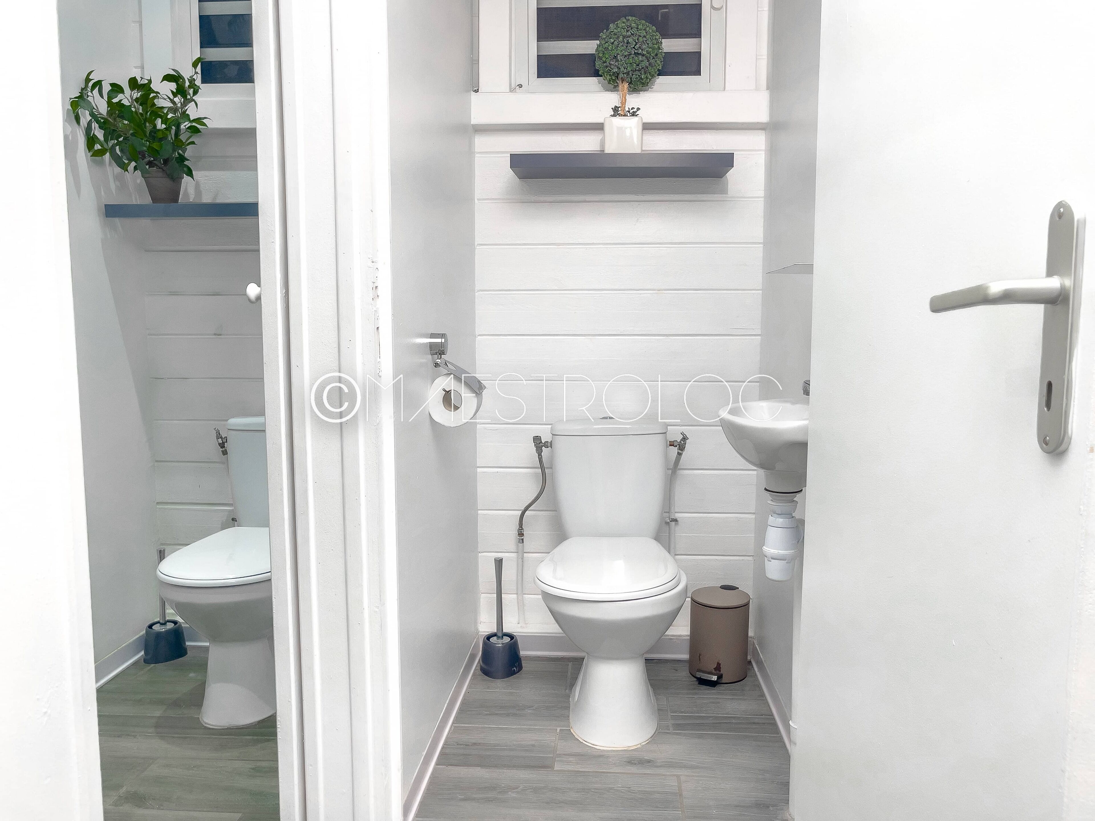 A compact bathroom with two toilets, a sink, and a small trash bin.