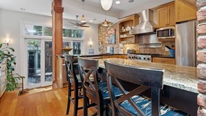 Eine moderne Küche mit einer zentralen Kochinsel, Holzschränken und einem großen Fenster.