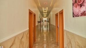A hotel hallway with marble flooring, wooden doors, and recessed lighting. - Timeless Beach Resort and Hotels (Lekki)