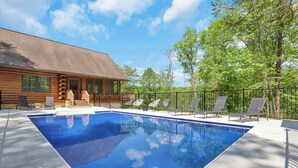 A wooden cabin with a swimming pool, surrounded by a fence and trees. - 11,000sqft sleeps 29, w/ POOL! private lake, hiking trails, hot tub, 130 acres! (Logan)