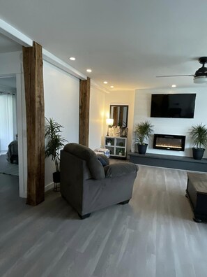 Una Smart TV, una chimenea, libros, una pantalla de ordenador