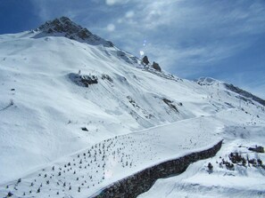 Surrounded by majestic mountains, this serene landscape offers breathtaking views of snow-covered peaks and a rocky outcrop.