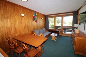 Relax in this inviting room with a dining table, sofa, and TV, offering a view of the outdoors.