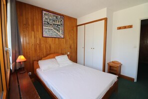 Relax in a cozy space with a large bed, framed artwork, and a convenient nightstand with a lamp.