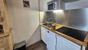 A compact kitchen with a microwave, stove, sink, and a small dishwasher. - 100m from resort center, Ground floor, tv, ski locker, 29m², Tignes (Tignes)