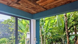 A view of The Retreat Restaurant's garden with a wooden deck and seating area. - The Retreat (Ribeira Grande)