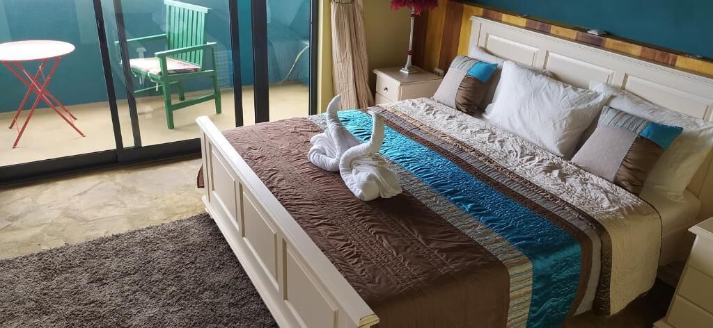 Un lit bien fait, recouvert d’une couvre-lit à rayures, avec deux serviettes blanches pliées posées sur le dessus.