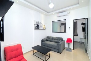 Deluxe appartement | Woonruimte | Een 32-inch lcd-televisie met kabelzenders en een televisie