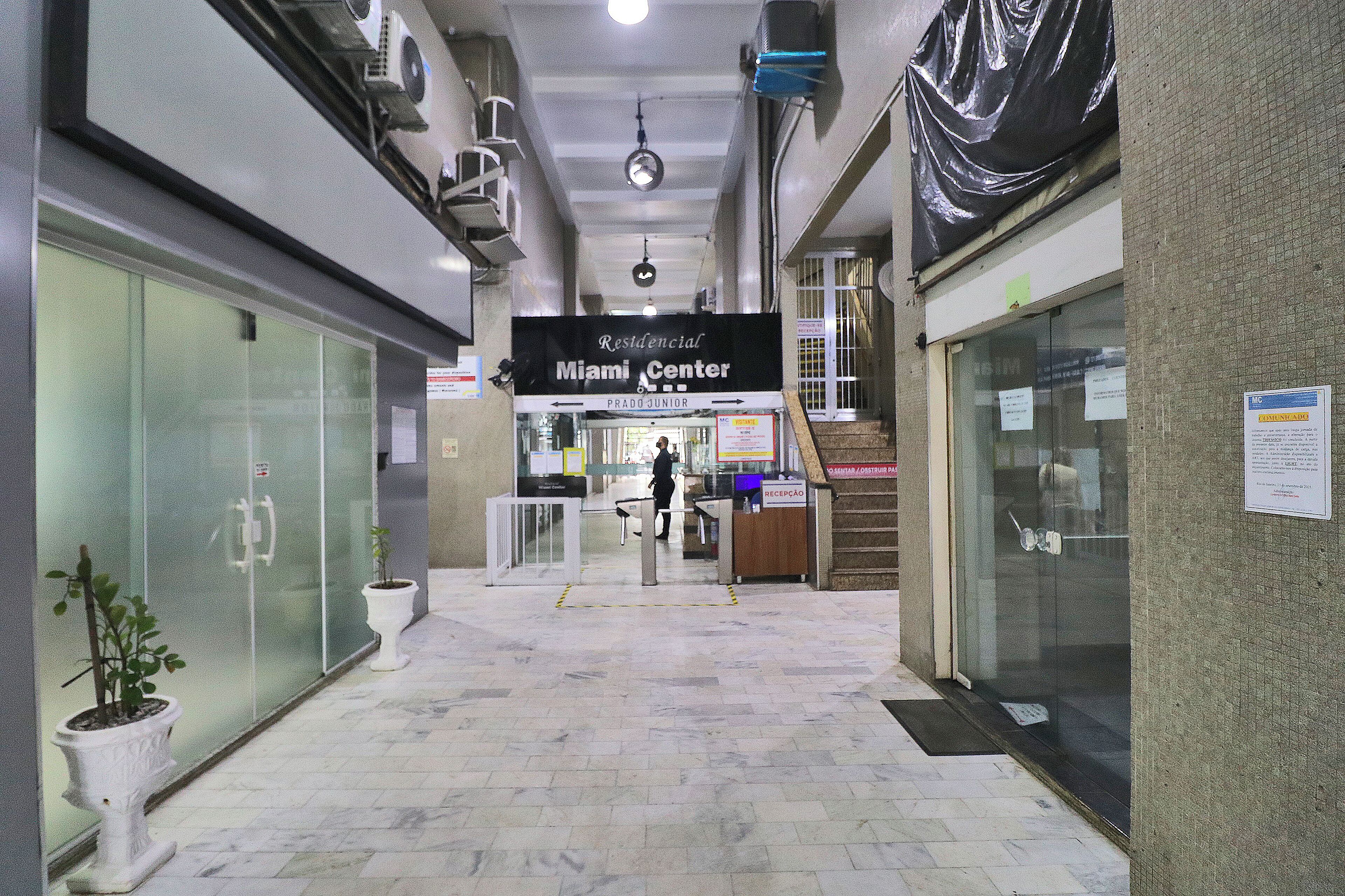 A hallway with a reception desk labeled "Residential Miami Center" and a staircase leading to an upper level.