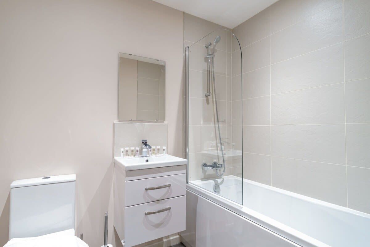 Bathtub, hair dryer, towels, shampoo