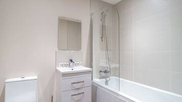 Bathtub, hair dryer, towels, shampoo