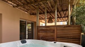 Ein Whirlpool mit Holzdach und Holzumzäunung.