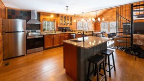 A modern kitchen with wooden cabinets, stainless steel appliances, and a central island. - Quiet Cabin On Over 12 Acres Of Woods! (Becket)