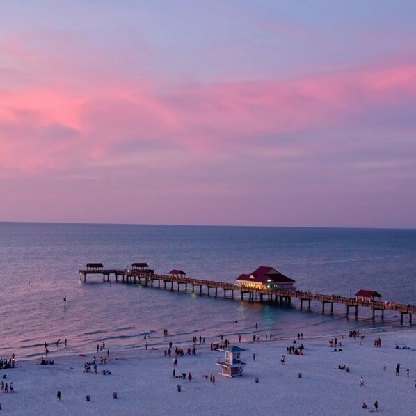 Enjoy a serene beach experience with a pier stretching into the calm waters.