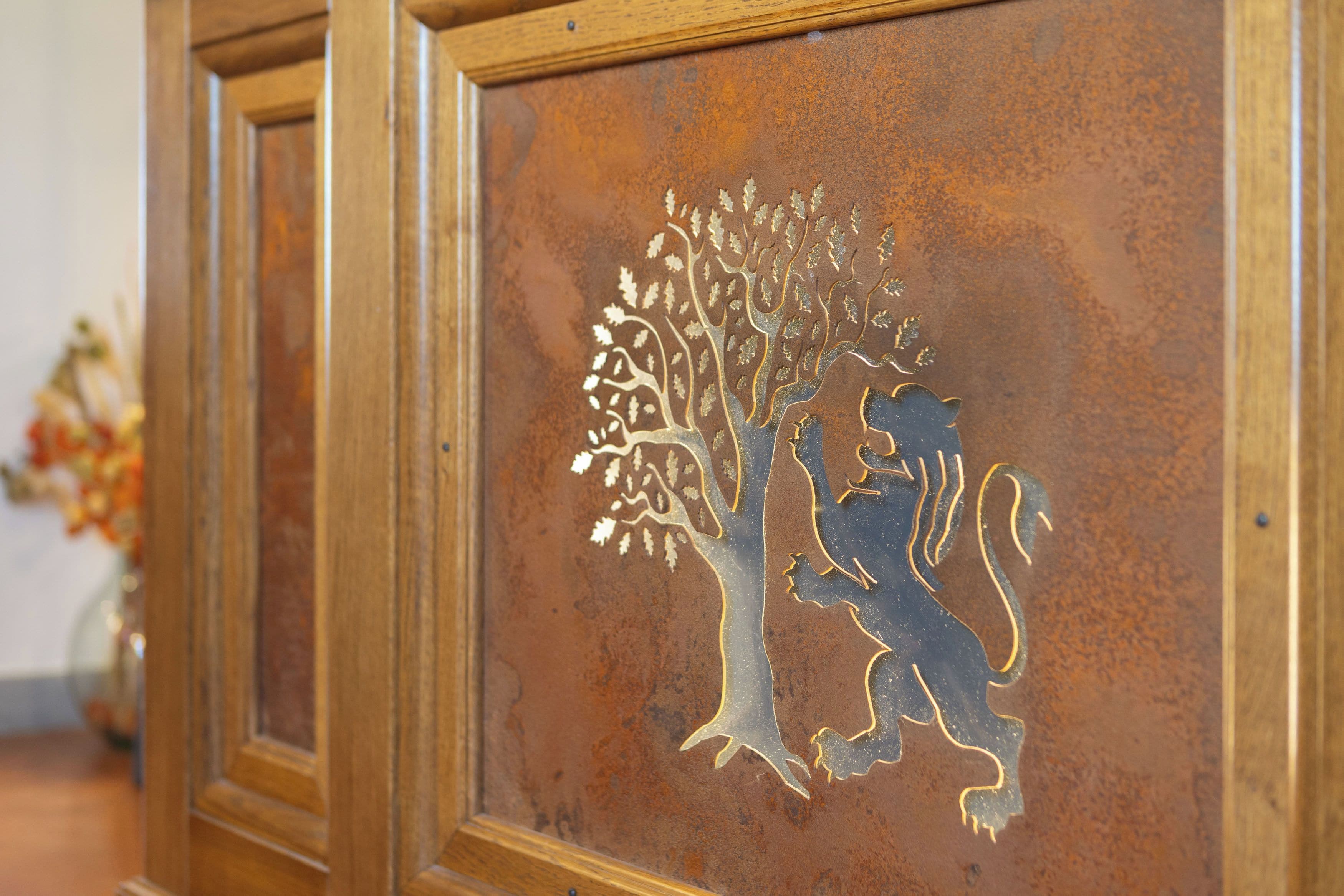 A decorative panel with a tree and lion design.