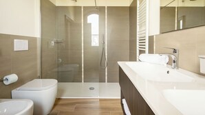 A modern bathroom with a glass-enclosed shower, a toilet, and a double sink vanity. - Podere La Quercia (San Gimignano)