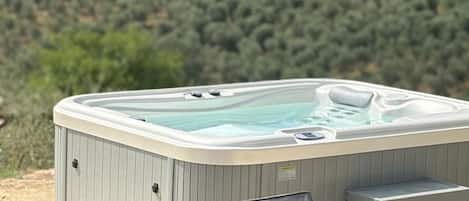 A hot tub with a view of a hilly landscape.