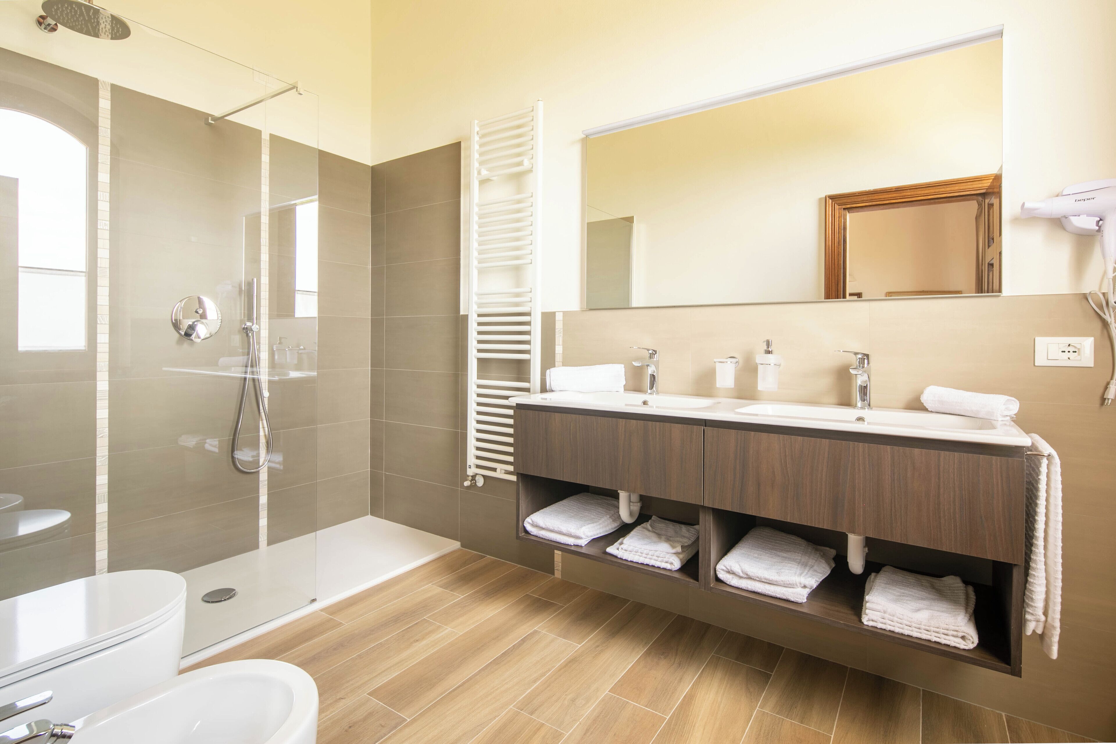 Une salle de bain moderne avec une douche à parois de verre, un meuble-lavabo avec un miroir et un porte-serviettes.