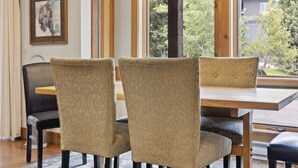 A dining area with a wooden table, four chairs, and a chandelier. - Outpost: Nez Perce C3 - Pool and Hot Tub Access! (Teton Village)