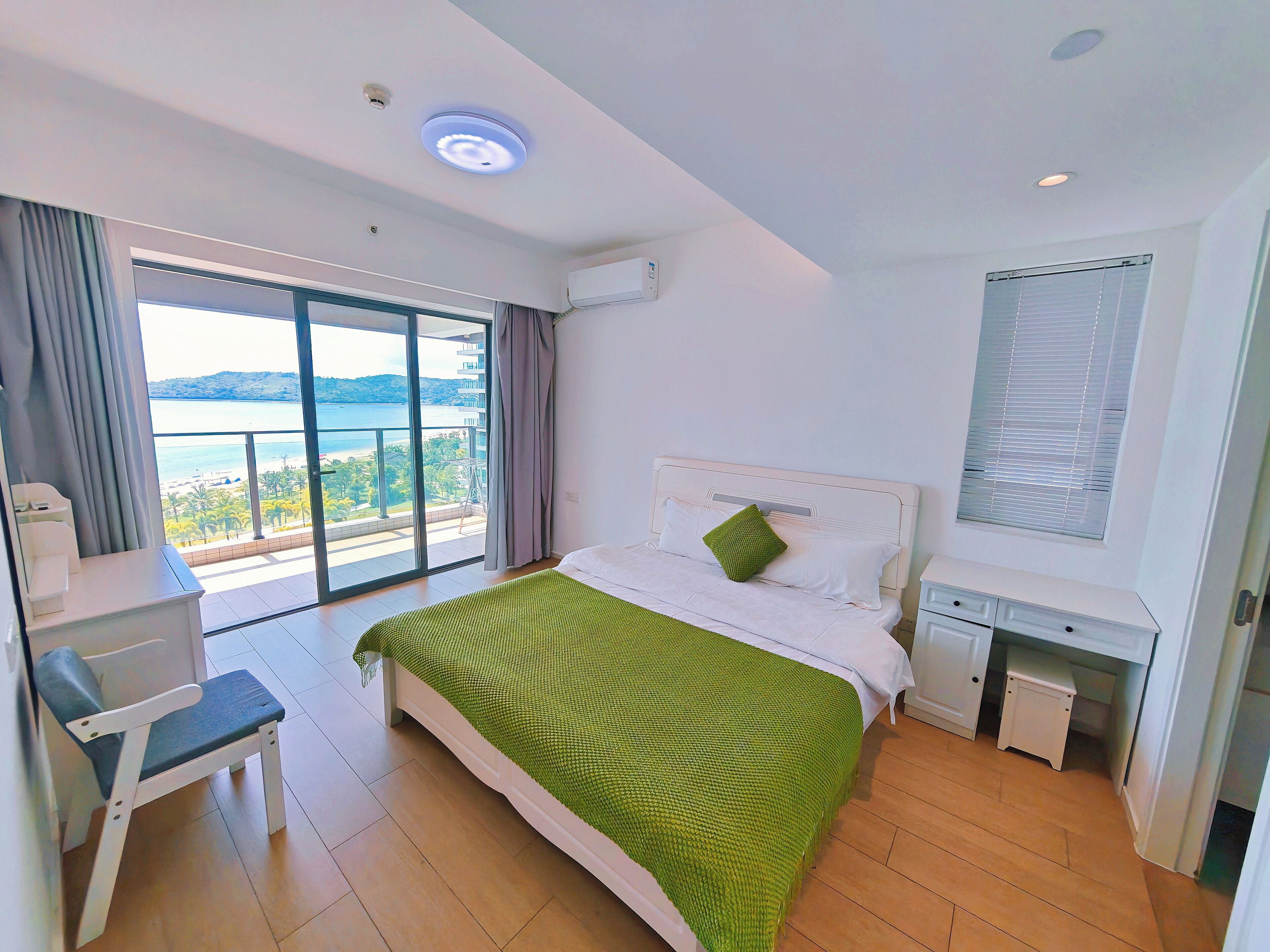 Ein Hotelzimmer mit Bett, Schreibtisch, Stuhl und Meerblick.
