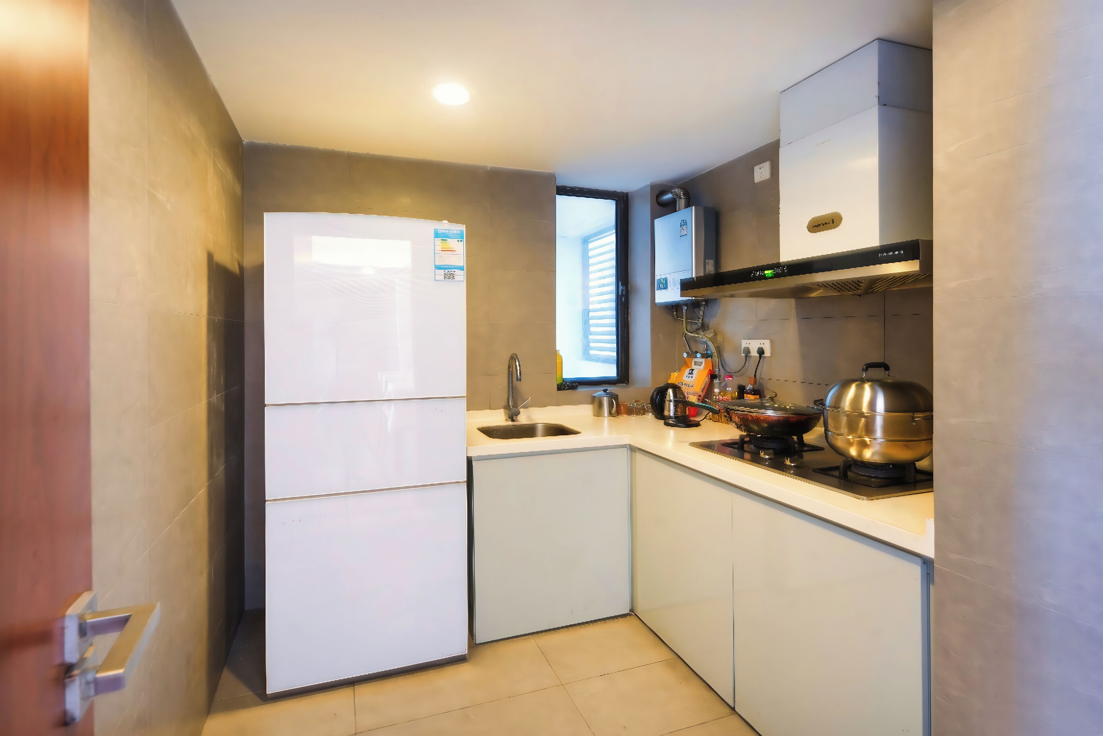 Una cocina compacta equipada con refrigerador, lavamanos, estufa y horno empotrado.