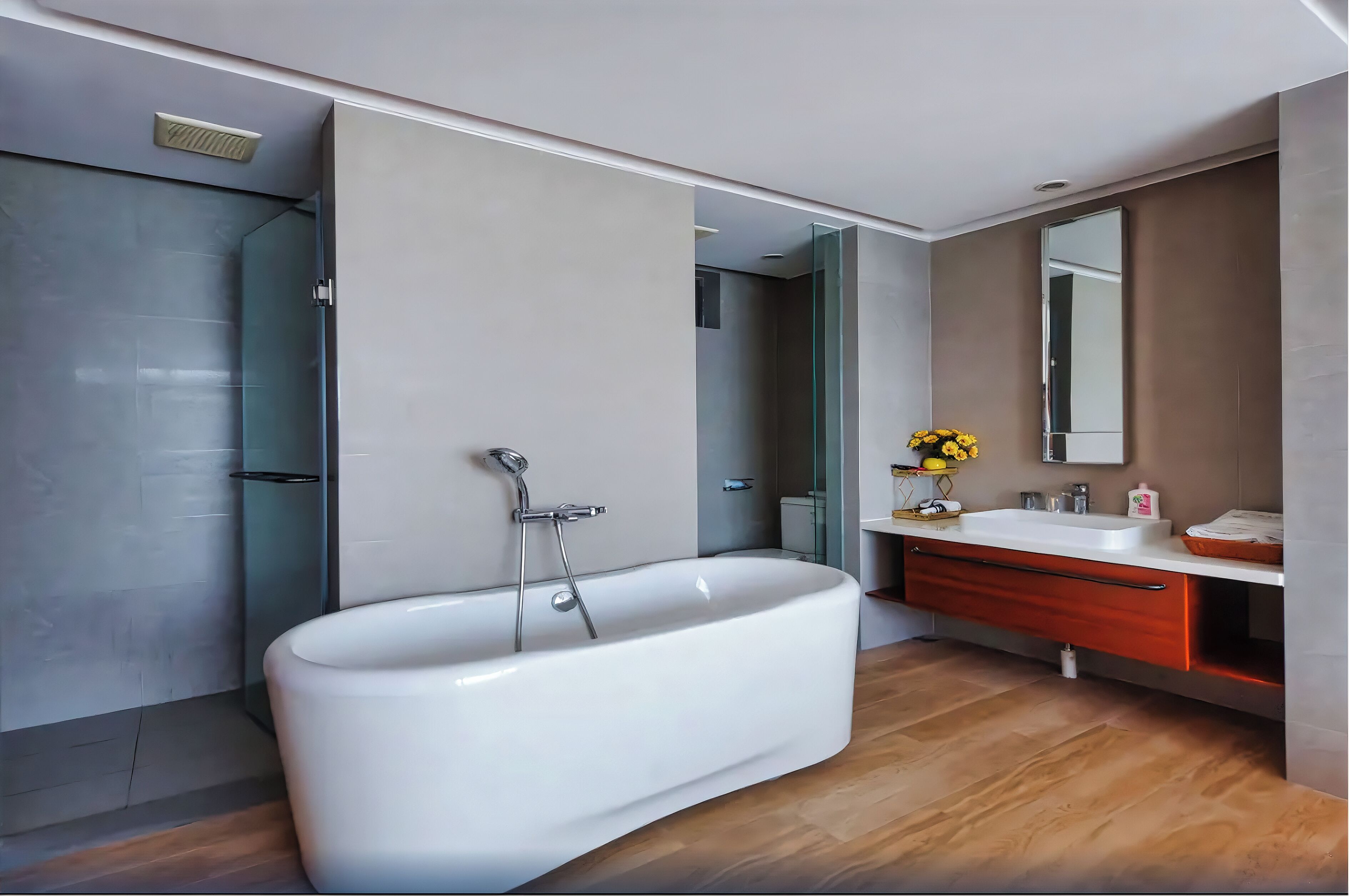 A modern bathroom with a freestanding bathtub, a glass shower enclosure, and a vanity with a mirror and sink.