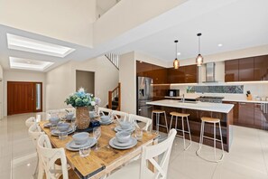 A modern kitchen with a central island, stainless steel appliances, and pendant lighting.