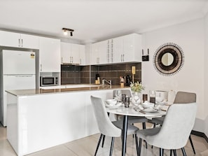 Enjoy cooking in the well-equipped kitchen with a central island, microwave and oven, and ample cabinetry.