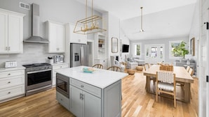 A modern kitchen with white cabinetry, stainless steel appliances, and a central island. - Jungle House-Heated Pool-Pet Friendly-Luxury (Edisto Island)