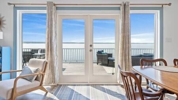 A room with a large sliding glass door leading to a balcony with outdoor furniture. - Long Point Lake House - Daphne's House (Aurora)