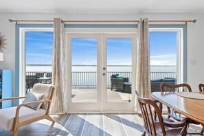 Habitació amb una gran porta corredissa de vidre que dona a un balcó amb mobiliari exterior.