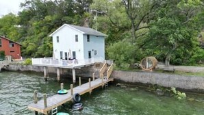 A houseboat with a dock, surrounded by water and greenery. - Long Point Lake House - Daphne's House (Aurora)