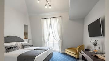 Una habitación de hotel moderna con una cama grande, un escritorio con una silla, un televisor de pantalla plana y una lámpara en el techo.