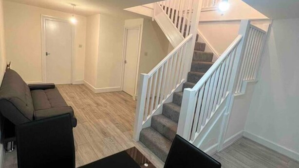 A spacious living area with a staircase, a sofa, and a dining table. - Spacious Luxury 2 Bedroom Apartment, Station 1min (London)