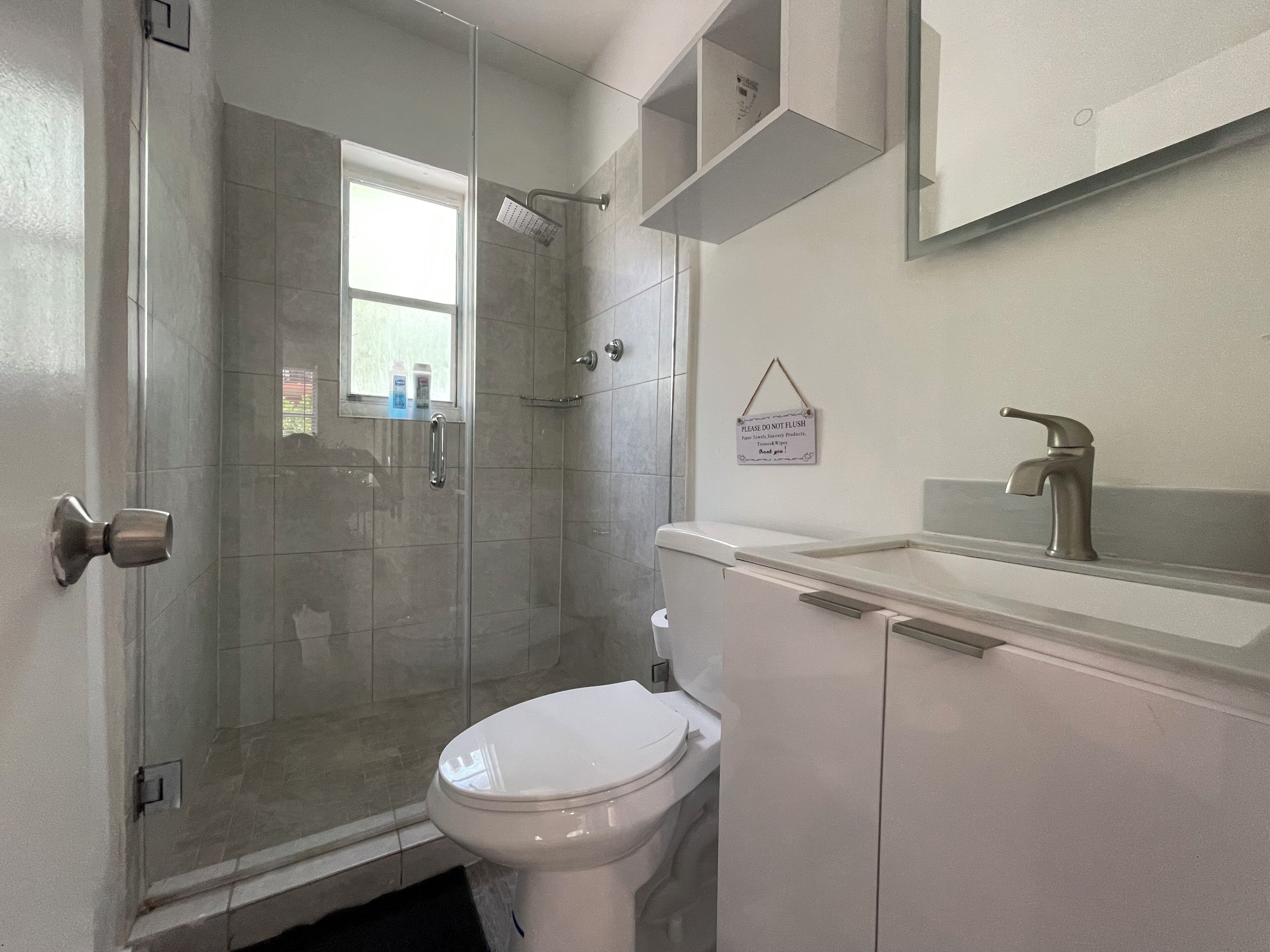 A bathroom with a shower, toilet, and sink.