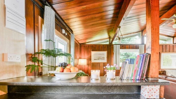 A kitchen with a marble countertop, wooden cabinets, and a ceiling fan. - Perfect wooden lodge for golfers & families, close to St. Andrews (New Gilston)