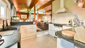 A modern kitchen with wooden beams, a large island, and stainless steel appliances. - Perfect wooden lodge for golfers & families, close to St. Andrews (New Gilston)