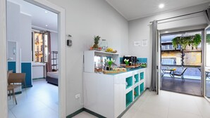 A modern kitchen with a central island, a dining area with a table and chairs, and a balcony with a view. - Royal Rooms Station Napoli (Naples)