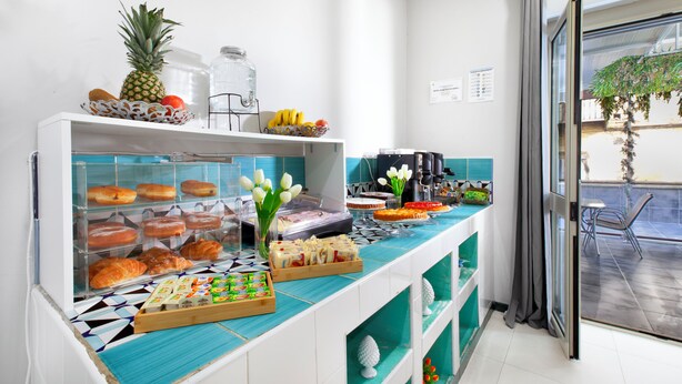 A breakfast buffet with various pastries, fruits, and beverages. - Royal Rooms Station Napoli (Naples)