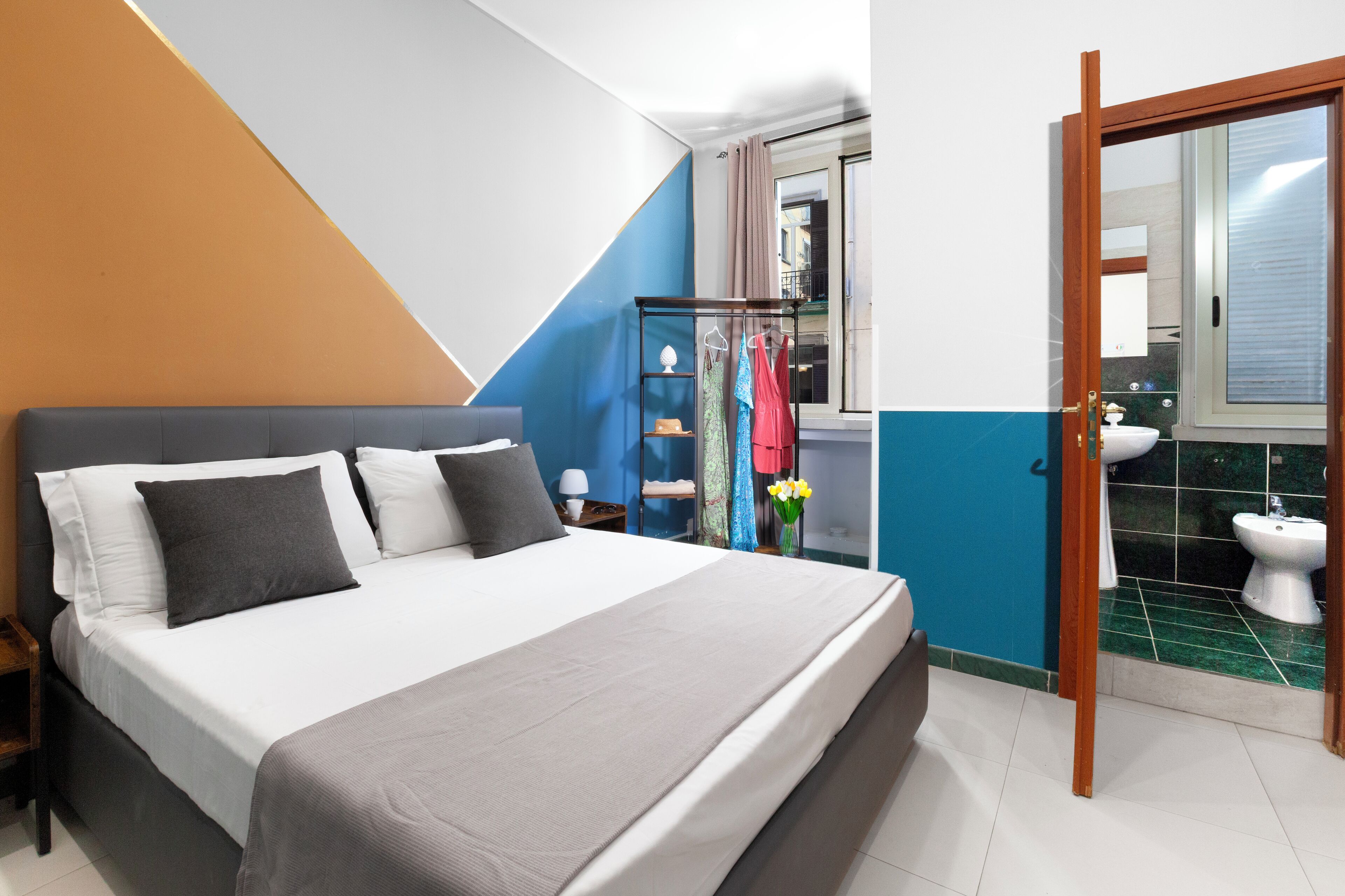 Een slaapkamer met een bed, nachtkastje en een kledingkast.