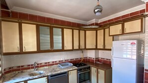 Eine Küche mit Holzausstattung, einem Spülbecken, einem Herd und einem Kühlschrank.