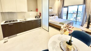 Appartement (0 Bedroom) | Privékeuken | Een magnetron, een oven, kookgerei, borden en bestek, een vriezer