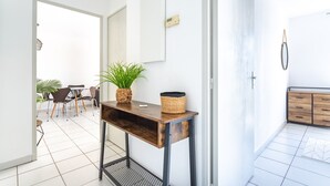 A modern living room with a wooden coffee table, a potted plant, and a wall-mounted thermostat. - La Castillane - Appt avec piscine partagée (Cavalaire-sur-Mer)