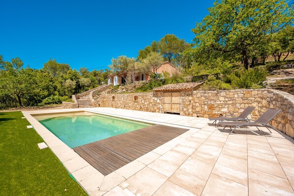 A swimming pool with a wooden deck, stone walls, and a grassy area. - Casa Hestia - Avec piscine privée (Entrecasteaux)