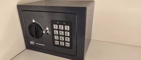 Een zwarte kluis met numeriek toetsenpaneel en sleutelgat, aangeduid met 'STANDERS'.